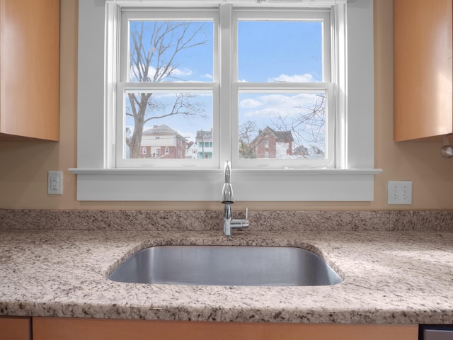 room details featuring light stone counters and a sink