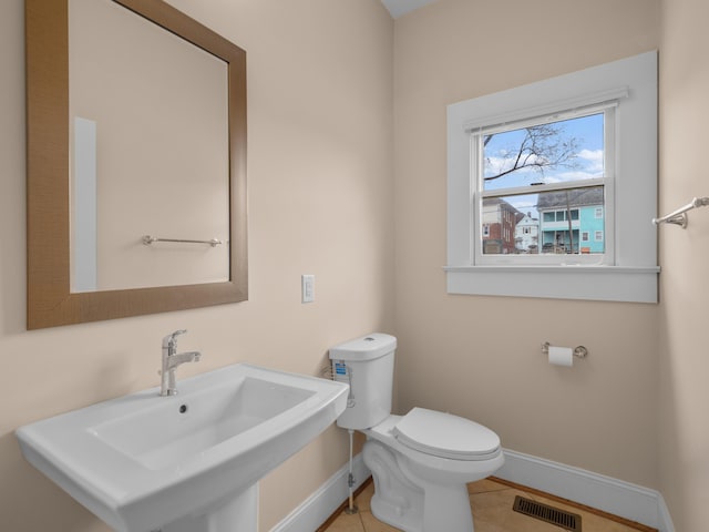 bathroom featuring toilet, baseboards, visible vents, and a sink