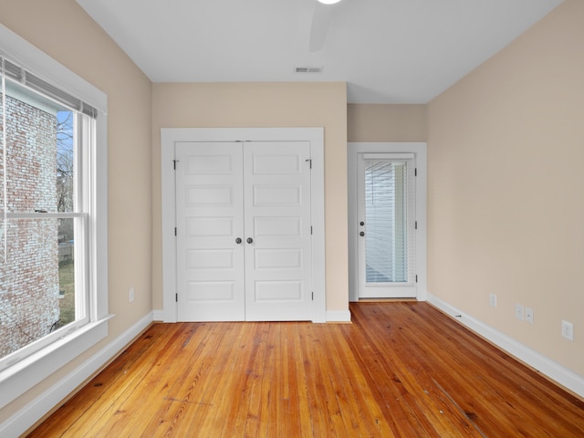 foyer featuring visible vents, baseboards, light wood-style flooring, and a ceiling fan