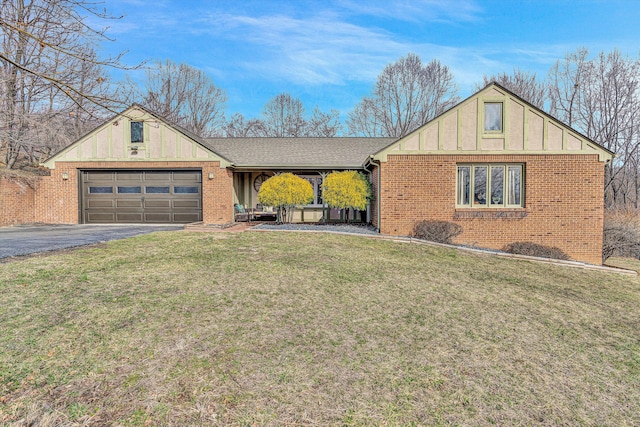 view of front of house with driveway, roof with shingles, a front lawn, a garage, and brick siding