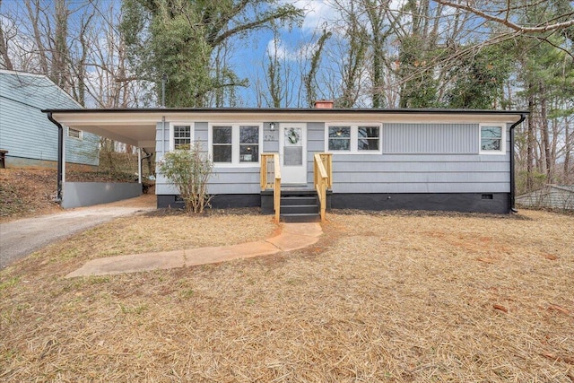 ranch-style home with crawl space, driveway, and a carport