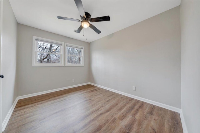 empty room featuring a ceiling fan, baseboards, and wood finished floors