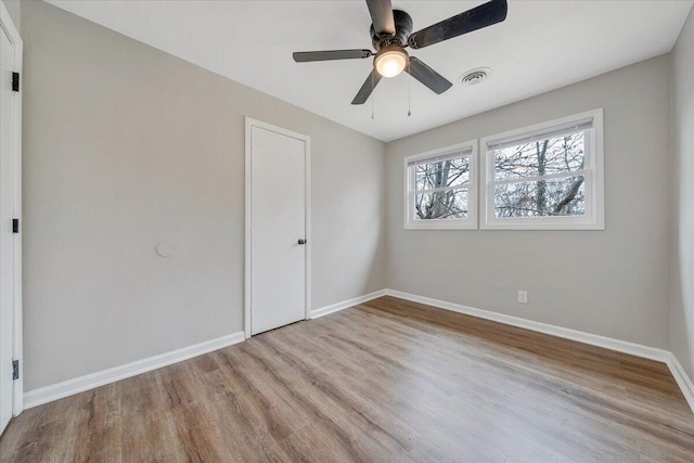 unfurnished bedroom with visible vents, wood finished floors, baseboards, and ceiling fan