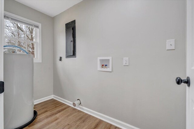 clothes washing area featuring baseboards, light wood-style floors, washer hookup, and laundry area