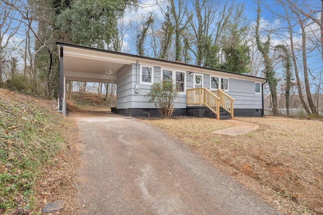 manufactured / mobile home featuring aphalt driveway and crawl space