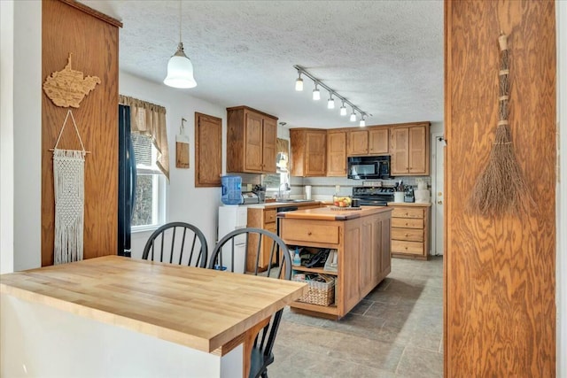 kitchen with electric stove, wood counters, a textured ceiling, black microwave, and a sink