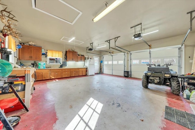 garage featuring a garage door opener and freestanding refrigerator