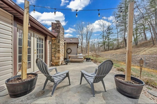 view of patio / terrace featuring french doors and fence