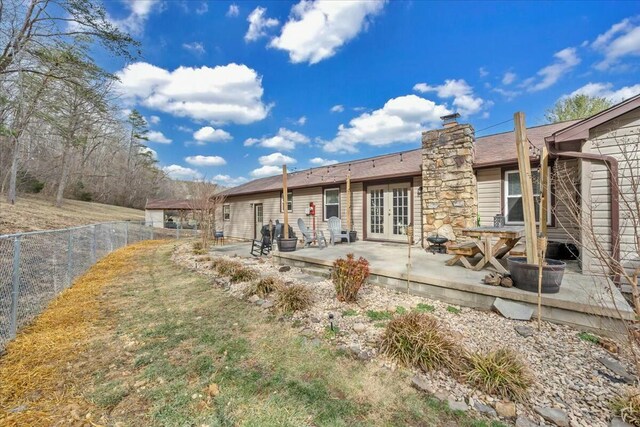 back of house with french doors, fence, a chimney, and a patio