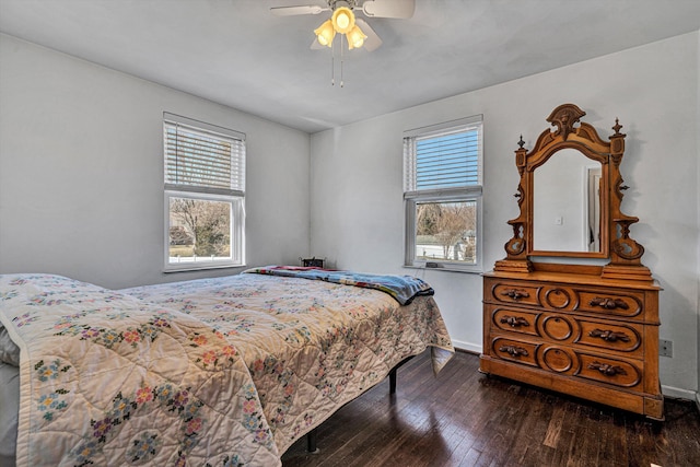 bedroom featuring a ceiling fan, multiple windows, baseboards, and hardwood / wood-style flooring