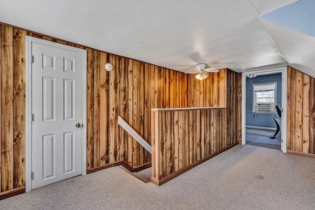 additional living space with lofted ceiling, wood walls, and carpet