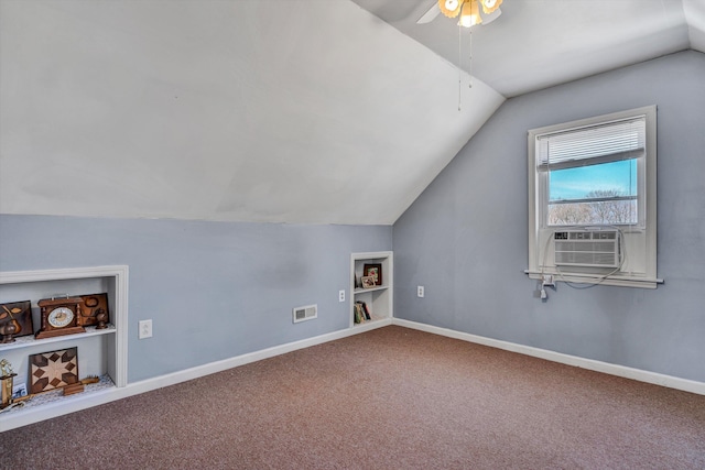 additional living space with built in shelves, carpet, lofted ceiling, visible vents, and baseboards