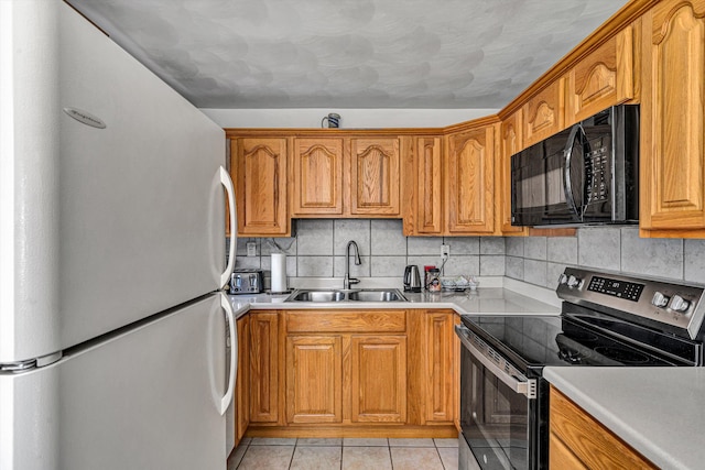 kitchen featuring brown cabinets, backsplash, stainless steel appliances, and a sink