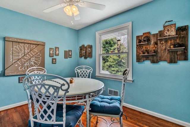 dining area featuring a ceiling fan, visible vents, baseboards, and wood finished floors