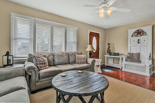 living room with ceiling fan, baseboards, and wood finished floors