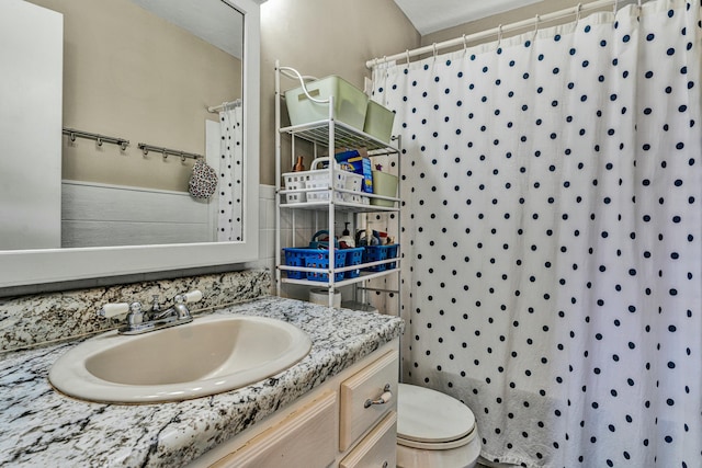 full bathroom with tile walls, curtained shower, vanity, and toilet