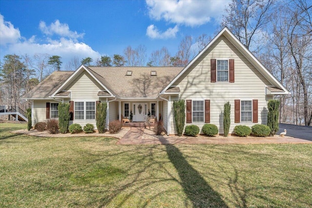 view of front of home with a front yard and roof with shingles