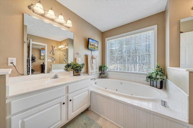 full bathroom with tile patterned floors, a textured ceiling, vanity, and a whirlpool tub