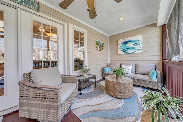 sunroom with a ceiling fan and baseboard heating