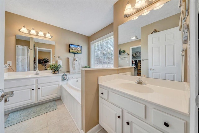 full bathroom featuring tile patterned flooring, two vanities, a garden tub, and a sink