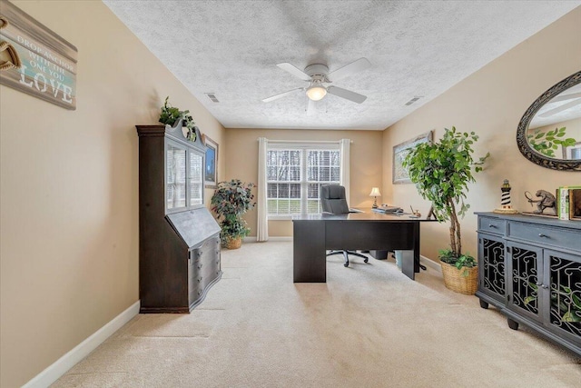 home office with baseboards, carpet, ceiling fan, and a textured ceiling