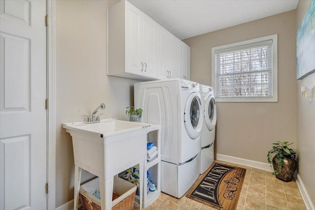 laundry area featuring baseboards, cabinet space, and washer and clothes dryer