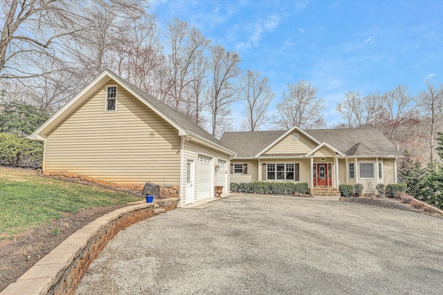 view of front facade with a front lawn, an attached garage, and driveway