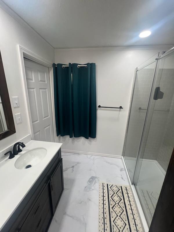 bathroom featuring marble finish floor, a stall shower, and vanity