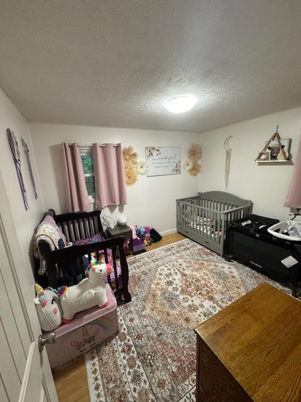 bedroom with wood finished floors and a textured ceiling