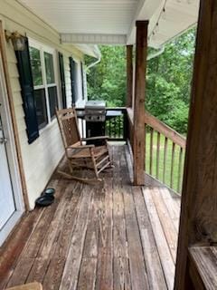 wooden deck featuring grilling area and a porch