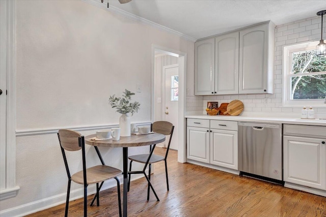 kitchen featuring a wealth of natural light, dishwasher, light wood-type flooring, and crown molding