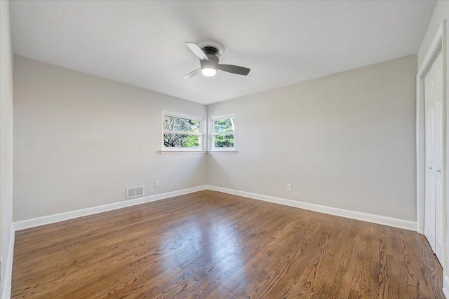 empty room with visible vents, baseboards, a ceiling fan, and wood finished floors