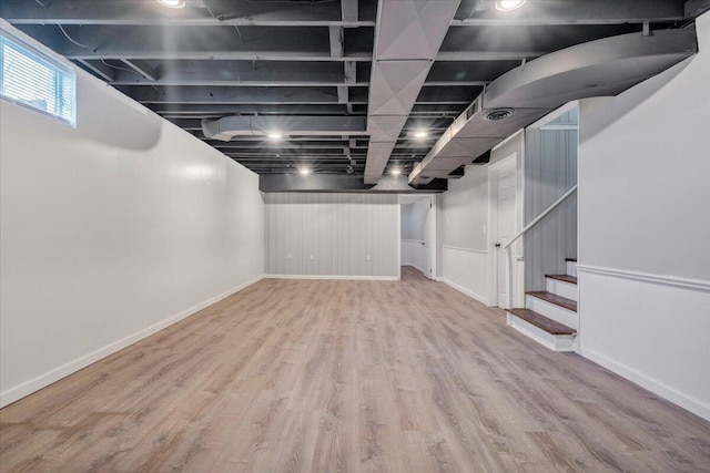 basement with visible vents, baseboards, wood finished floors, and stairs