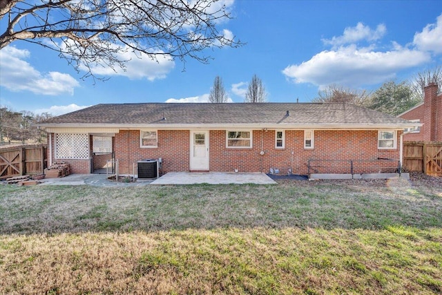 rear view of property with a fenced backyard, cooling unit, a yard, brick siding, and a patio area