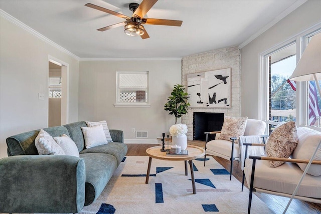 living area with visible vents, wood finished floors, and ornamental molding