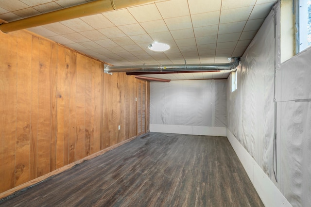 below grade area featuring wooden walls, wood finished floors, and baseboards