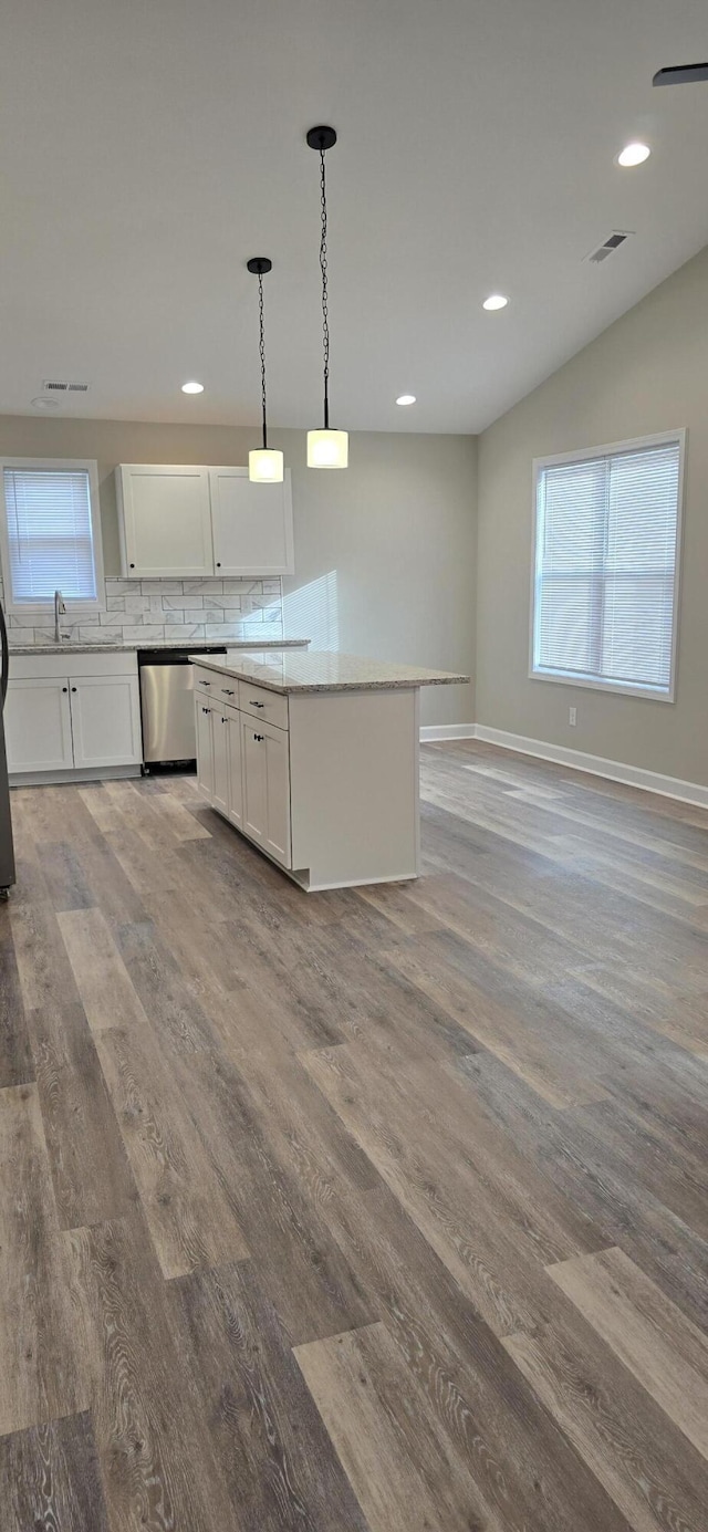 kitchen featuring a sink, dishwasher, wood finished floors, and white cabinetry