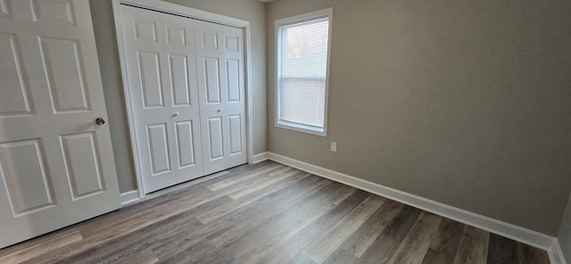 216 Franklin Ave, Vinton, VA 24179 - unfurnished bedroom featuring a closet, dark wood-style flooring, and multiple windows