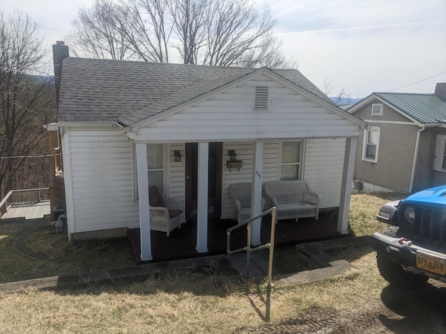 view of front of house with a chimney and roof with shingles