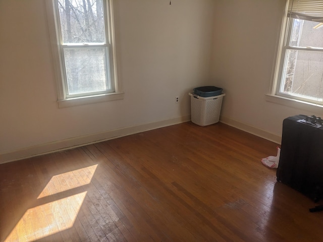 empty room featuring baseboards and hardwood / wood-style flooring