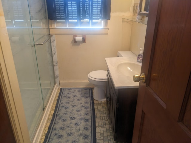 full bathroom featuring baseboards, a shower stall, vanity, and toilet