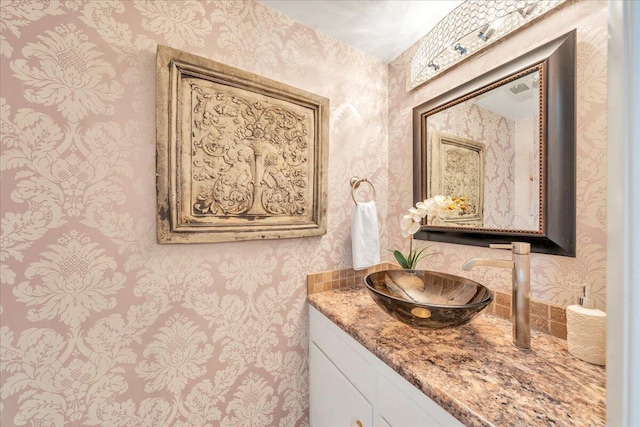 bathroom with vanity and wallpapered walls