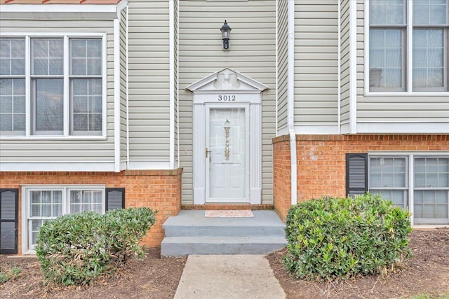 doorway to property with brick siding