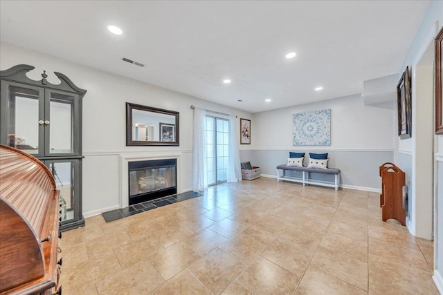 living room featuring recessed lighting, visible vents, a fireplace with flush hearth, and baseboards