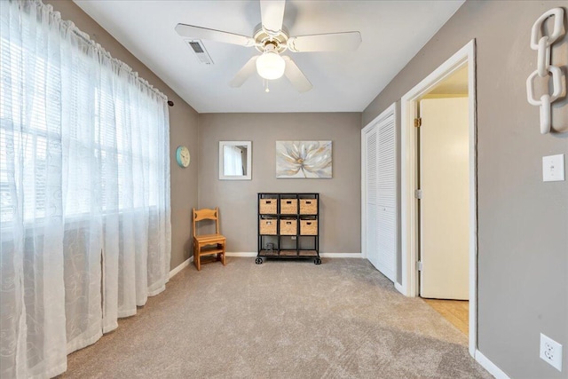 sitting room with baseboards, carpet flooring, a ceiling fan, and visible vents