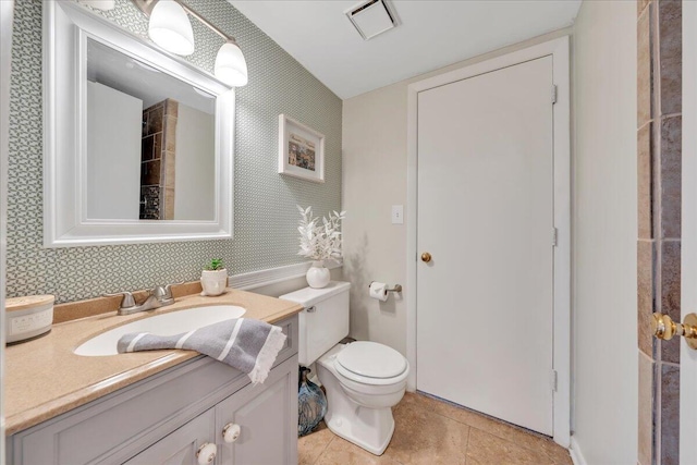 bathroom with vanity, toilet, tile patterned flooring, and wallpapered walls