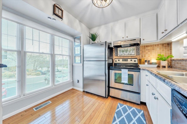 kitchen with visible vents, white cabinets, under cabinet range hood, appliances with stainless steel finishes, and backsplash