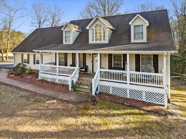 cape cod home featuring a porch and a shingled roof