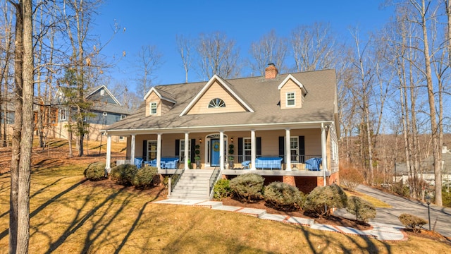 view of front facade featuring covered porch, a chimney, and a front lawn