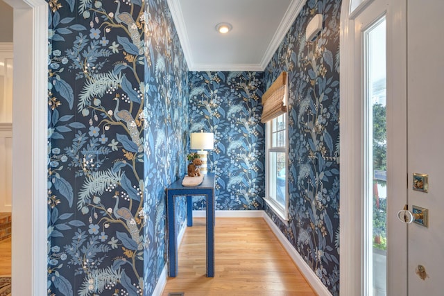 interior space with wallpapered walls, wood finished floors, baseboards, and ornamental molding